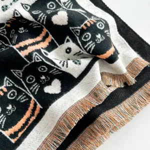 Close-up of winter knitted cat scarf detail, cute pattern design with fringe edges.