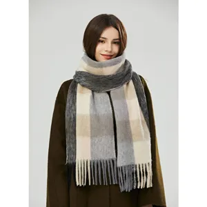 Close-up detail of the cozy fuzzy plaid winter scarf featuring soft mohair blend and fringe hem.