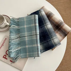 Detailed shot of cozy winter tassel scarves with classic plaid and gradient designs on table.