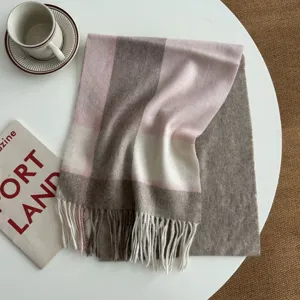 Cozy winter plaid scarf detail showing soft wool texture and classic fringe design for warmth.