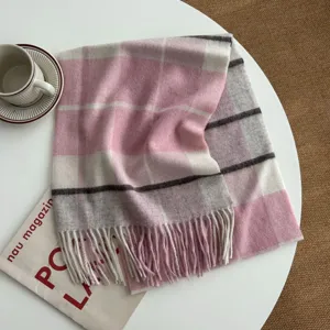 Detailed close-up view of a pink and white plaid winter scarf featuring soft woolen texture.