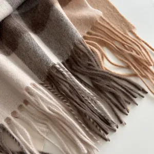 Close-up detail shot of classic UK style plaid wool winter scarf with soft warm fringe design.
