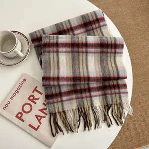 Detail shot of cozy plaid winter scarf with fringe, soft woven texture for cold weather.