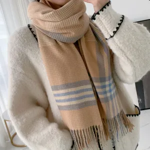 Close-up detail of a classic plaid cashmere-feel winter scarf, soft tassel fringe.