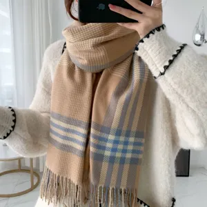 Close-up detail of the classic plaid winter scarf featuring soft cashmere-feel fabric and fringe.