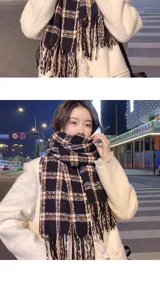 Black and white plaid scarf with fringe detail, cozy winter neck warmer close-up.