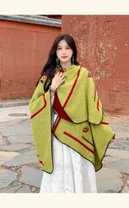 Detailansicht des ethnischen grünen Ponchos mit warmem Strick und bunten Akzenten.