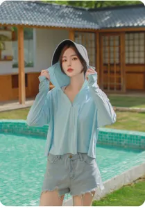 Vue détaillée du sweat à capuche anti-UV léger porté par un mannequin près de la piscine.