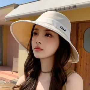 Beige wide brim bucket hat for women, summer UV protection sun hat for beach and outdoor travel.
