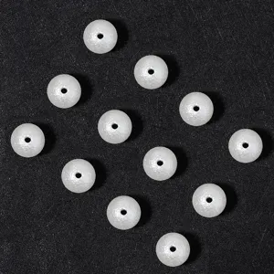 Detail shot of frosted white imitation pearl beads with hole, perfect for DIY jewelry crafting.