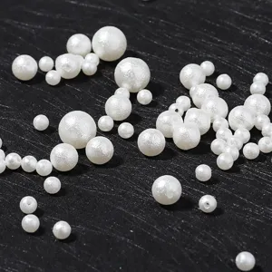 Detailed close-up shot of white ABS imitation pearl beads with frosted and glossy finish for DIY.