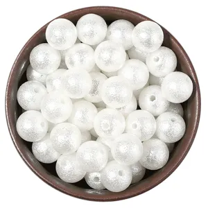 Detail view of matte white imitation pearl beads with holes, perfect for DIY wedding jewelry crafts.