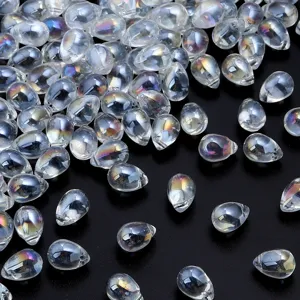 Primer plano de cuentas de cristal transparentes en forma de lágrima con brillo iridiscente.