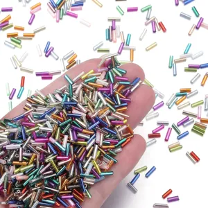 Primo piano di perline di vetro colorate in mano, perfette per la creazione di gioielli.