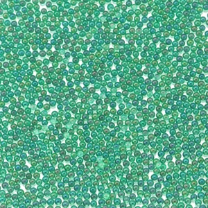 Primer plano detallado de pequeñas cuentas de vidrio iridiscentes verdes para rellenar resina.