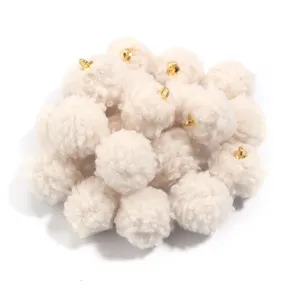 Close-up detail of fluffy teddy fur pom-pom charms with gold loops, perfect for DIY jewelry.