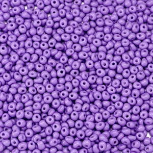 Macro close-up detail of purple loose glass seed beads for handmade DIY jewelry making.