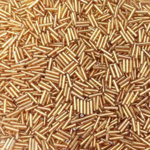 Primo piano dettagliato di perline tubolari in vetro dorato lucido, perfette per la creazione DIY.