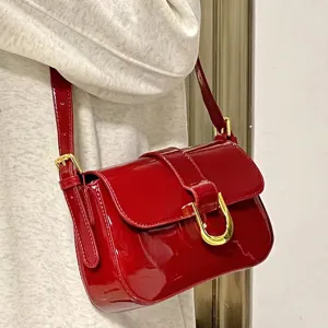 Wine red patent leather shoulder bag with gold horseshoe buckle for women fashion.