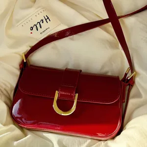 Vintage glossy patent leather shoulder bag with horseshoe buckle, elegant red crossbody bag.