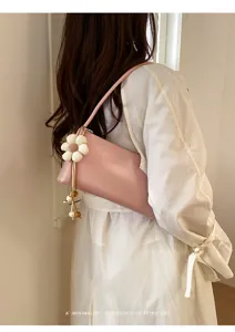 Detailed view of pink PU shoulder bag with white flower pendant, minimalist retro style.