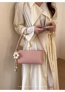 Elegant pink PU leather shoulder baguette bag with cute flower charm for women daily use.
