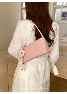 Pink PU leather shoulder bag for women, retro baguette underarm handbag with floral pendant.