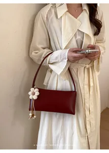 Detail shot of the vintage PU shoulder bag in burgundy, featuring a cute flower charm accent.