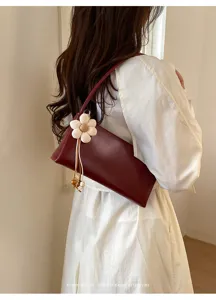 Retro PU shoulder bag detail showing dark red underarm design and cute flower charm accent.