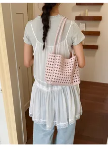 Pink woven shoulder tote bag for women, stylish hollow out leather handbag for daily fashion.