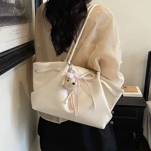 Detail view of a fashionable PU leather tote bag with a cute puppy keychain charm.