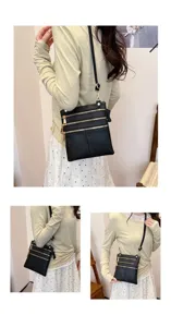 Detailed view of black leather crossbody bag featuring multiple zipper pockets and slim strap.