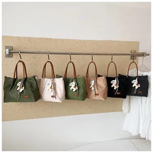 Vue détaillée de sacs cabas tendance en nylon avec poignées et adorables pendentifs animaux.