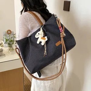 Vue détaillée du cabas à carreaux décontracté pour femmes avec bandoulière et charm cheval chic.