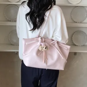 Detailed view of the stylish pink tote bag featuring a cute plush puppy charm, perfect for daily wear.