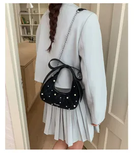 Detailed back view of a chic black quilted shoulder bag featuring elegant pearls and a cute bow.