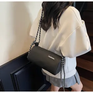 Detailed view of trendy black cylinder crossbody bag, waterproof pillow shoulder bag.