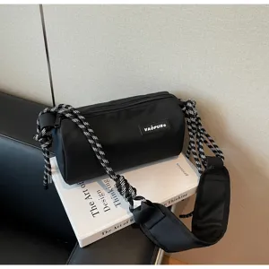Black waterproof cylindrical shoulder bag with thick patterned rope strap for casual everyday use.