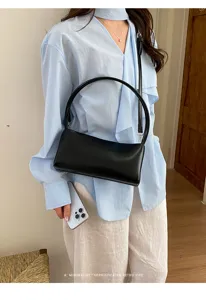 Detailed close-up view of a stylish black PU shoulder bag on a model, retro minimalist look.
