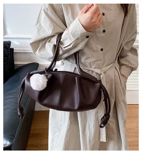 Dark brown soft leather shoulder bag detail, stylish cloud handbag with fluffy pom-pom.