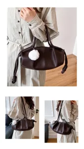 Detail view of women soft leather cloud shoulder bag with cute white pompom charm.