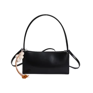 Minimalist black PU leather underarm shoulder bag with chic pendant for women daily wear