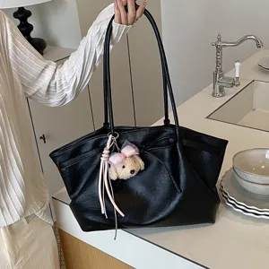 Detailed view of the black leather tote bag with cute puppy pendant and large capacity.