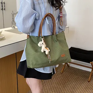 Sac cabas à carreaux vert avec poignées marron et charm cheval, détail de sac décontracté.