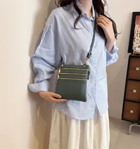 Women's dark green multi-zipper leather crossbody phone bag detail view, stylish and compact.