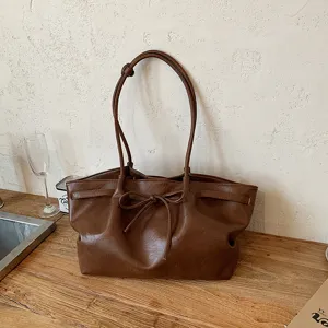 Brown vintage PU leather tote bag for women, stylish shoulder bag with bow detail.