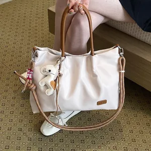 Sac cabas décontracté pour femme avec poignées marron et bandoulière en corde élégante.