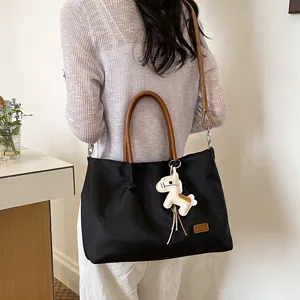 Femme sac cabas noir élégant sac bandoulière décontracté sac à main de trajet avec pendentif.