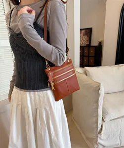 Women brown leather crossbody bag with multiple zippers for daily casual wear and travel use.
