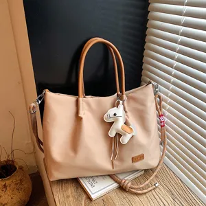 Vue détaillée du sac cabas décontracté en nylon kaki avec bandoulière et charm cheval mignon.